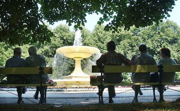 Un grupo de mayores descansa en un parque. 