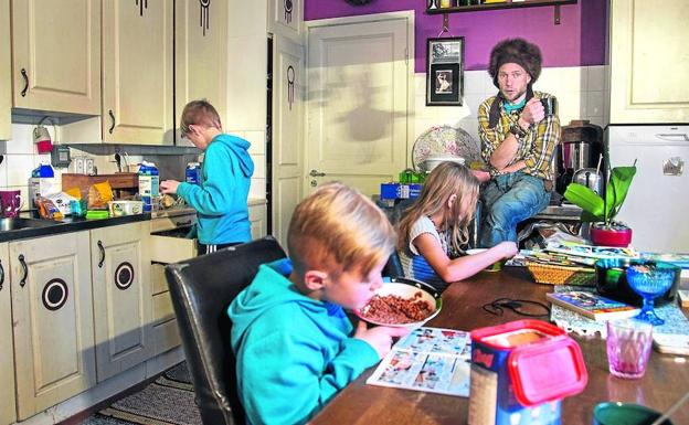 Juha Järvinen, perceptor de la renta básica en Finlandia, en la cocina de su casa junto a tres de sus seis hijos.