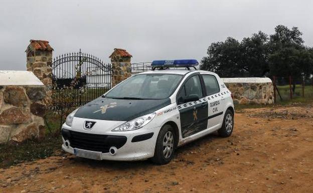 Un coche de la Guardia Civil en las inmediaciones de la finca «La lapa», en la localidad sevillana de Burguillos.
