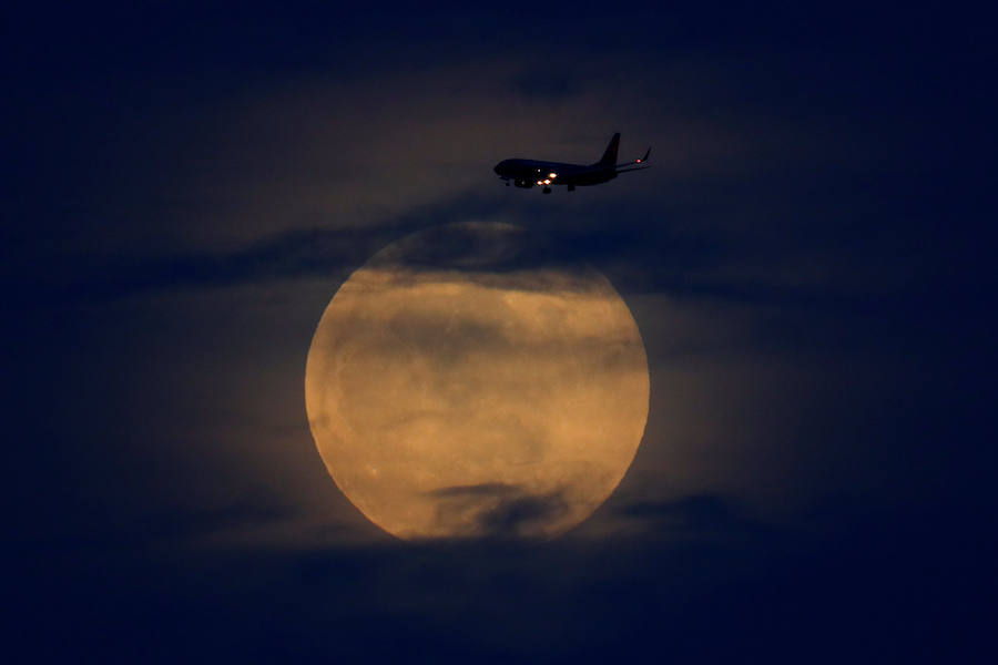 Un avión atraviesa la luna de sangre en San Diego, California (EE UU). 