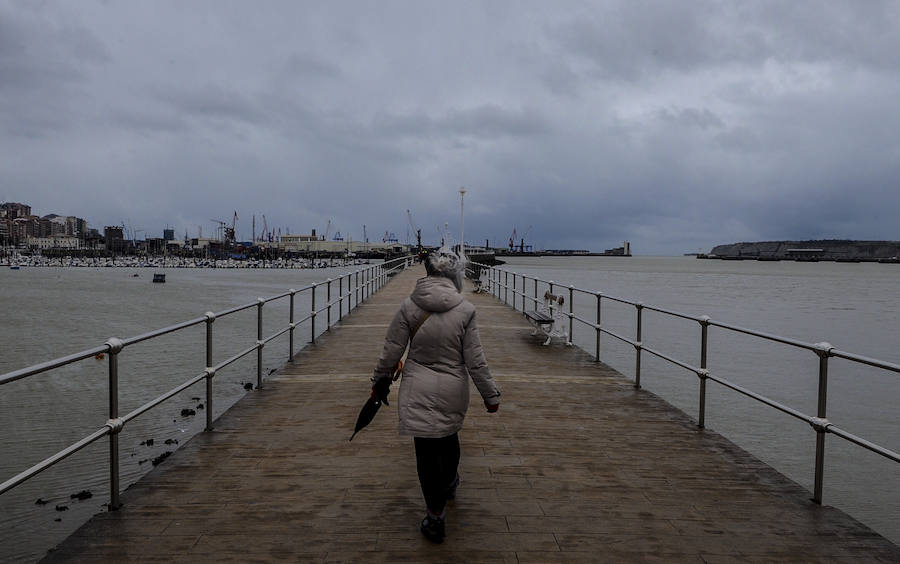 Una mujer pasea por el muelle de Portugalete.