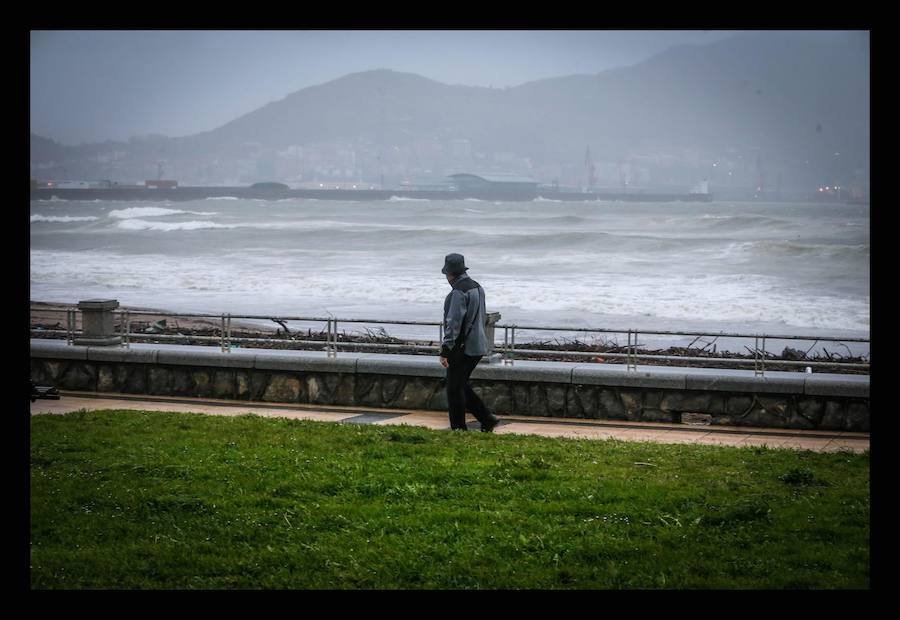 Un hombre pasea por el paseo de la playa de Ereaga.