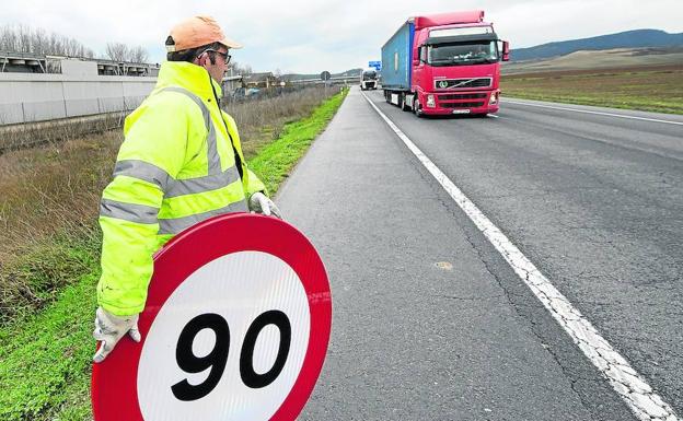 Un operario se dispone a cambiar una señal de 90 en la N-124 a su paso por Álava en dirección a Haro.