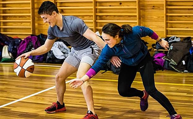 Dos universitarios de educación física, en una de las clases prácticas de baloncesto. 