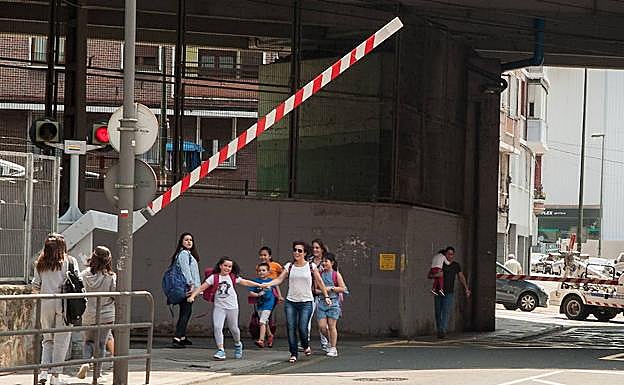 Vecinos del barrio cruzan el paso a nivel de Zorroza. 