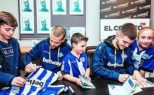 Laguardia y Martín escriben sendas dedicatorias a unos aficionados del Alavés.