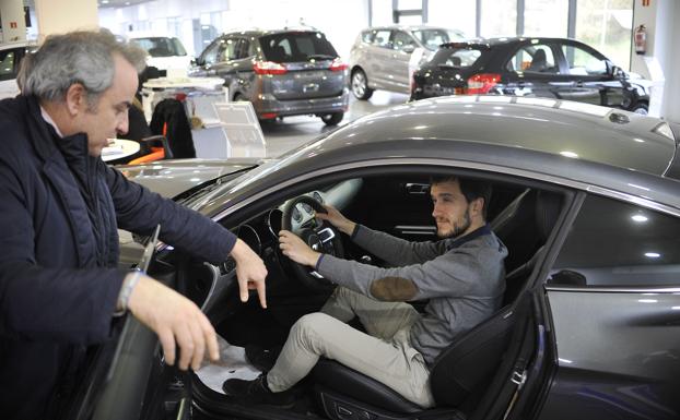 Un joven prueba un coche en un concesionario. 