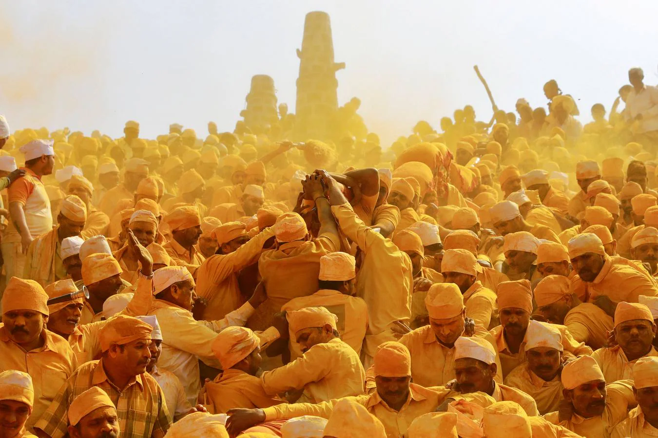 Devotos lanzan polvo de cúrcuma como ofrenda al dios pastor Khandoba mientras otros llevan un palanquín durante 'Somvati Amavasya' en un templo en Jejuri, India, el 4 de febrero.