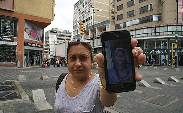 Nancy Martínez muestra la fotografía de su cuñado Javier en el móvil.