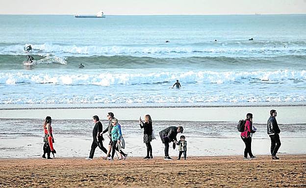 La playa de La Arena se llenó ayer de surfistas y paseantes ávidos de mar y sol. 