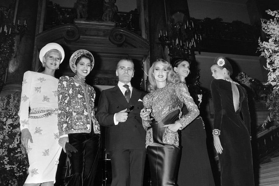 El diseñador posa con modelos, entre las que se incluye Jarry Hall, en 1984.