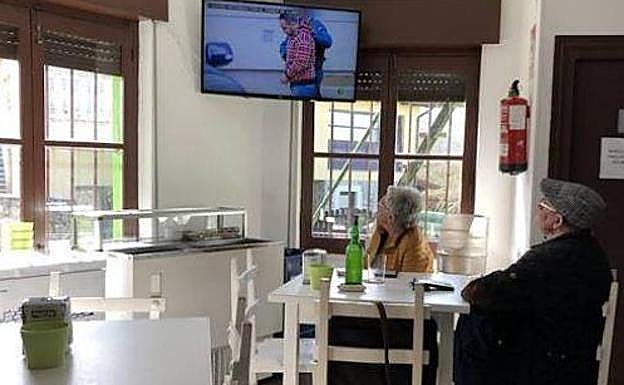 Vecinos del pueblo de Javier Ardines ven las noticias en la televisión del bar.