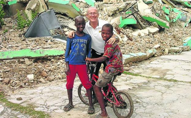 Linares, con dos niños haitianos tras el terremoto que asoló la isla.