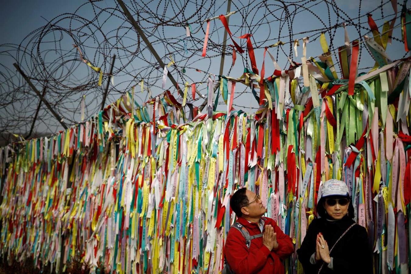 Turistas observan las cintas con mensajes de paz, en la franja desmilitarizada que separa a las dos Coreas, en Paju (Corea del Sur)