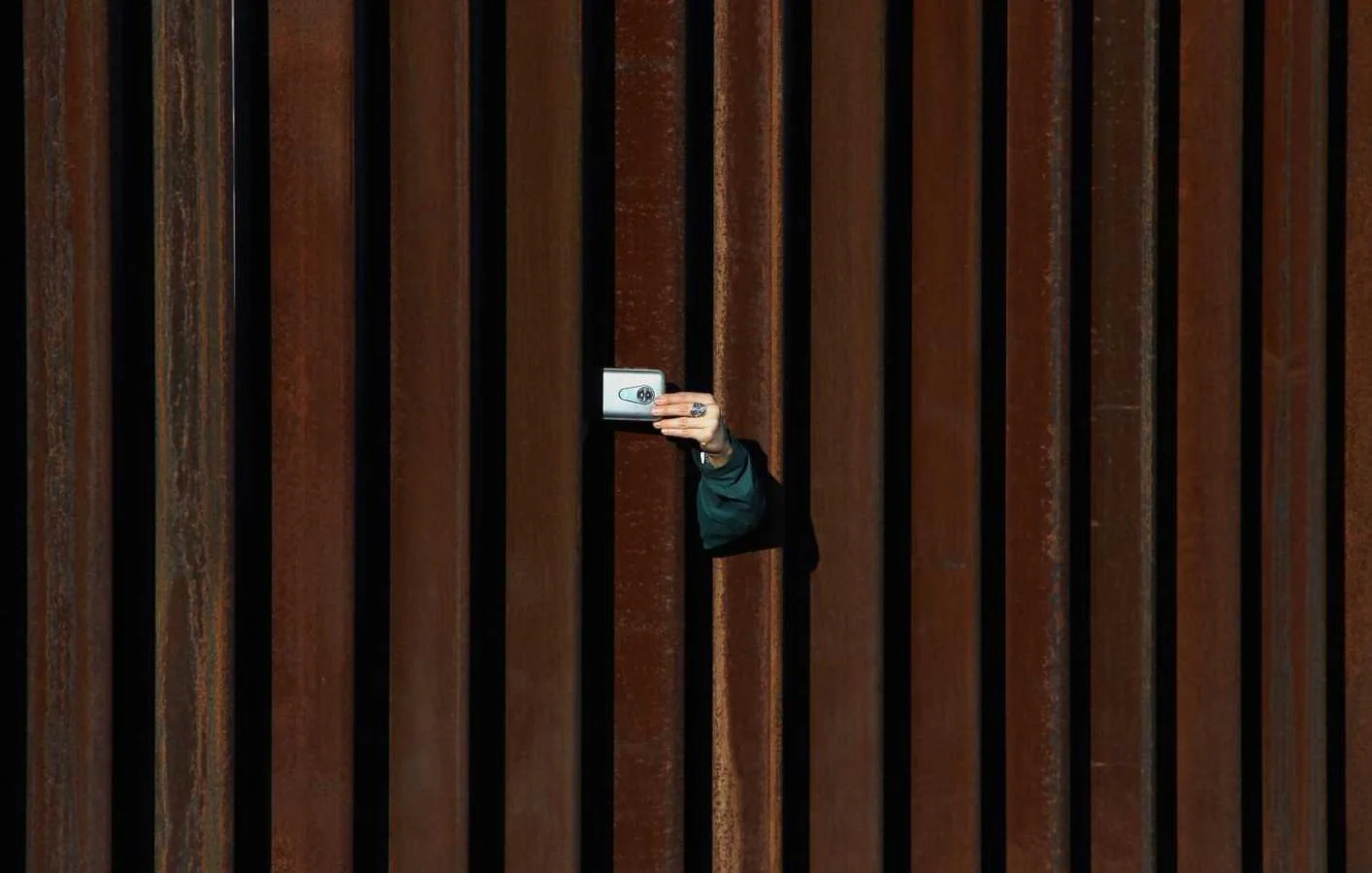 Una mujer desde Estados Unidos saca una foto a México a través del muro de Anapra, en Ciudad Juárez