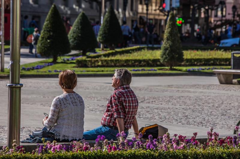 Dos personas disfrutan del buen tiempo en la Plaza Moyua. 