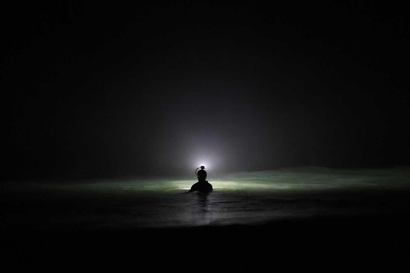 Los surfistas Yann Le Her, Alan, Yohann, Robin y Damien desafían el frío y la oscuridad en una sesión de surf nocturno en la playa del Cabo Fréhel, Bretaña