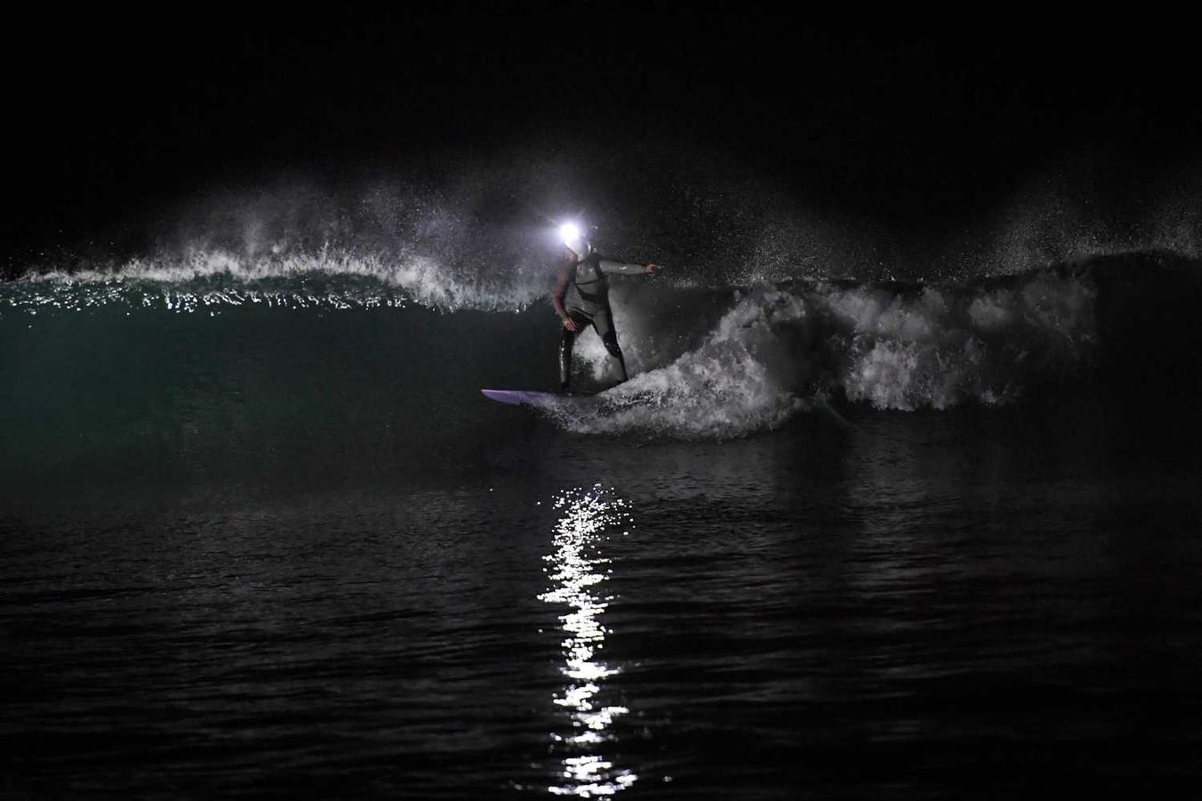 Los surfistas Yann Le Her, Alan, Yohann, Robin y Damien desafían el frío y la oscuridad en una sesión de surf nocturno en la playa del Cabo Fréhel, Bretaña