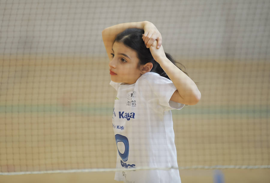 Una niña realiza estiramientos antes de comenzar los ejercicios con pelota.