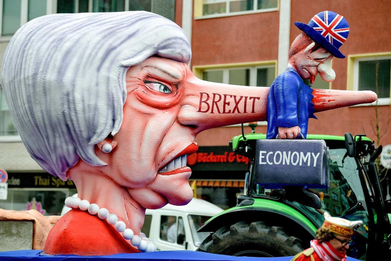 Carroza con una imagen paródica de la primera ministra británica, Theresa May, asesinando a la economía británica con mentiras, en el desfile anual del "Lunes de la rosa" en Düsseldorf (Alemania)