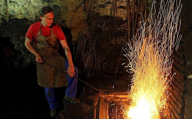 Un ferrón atiza el fuego en El Pobal.