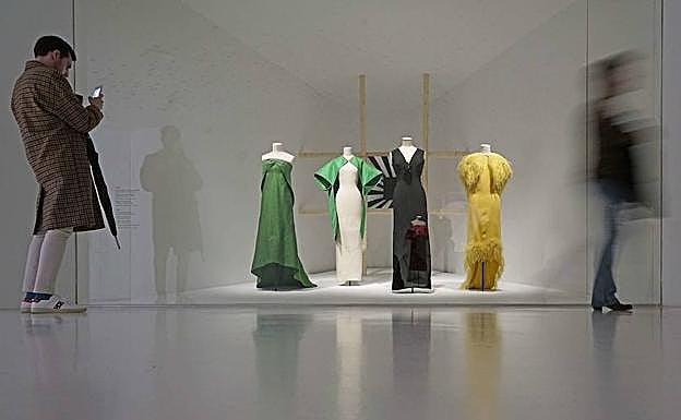 Un visitante fotografía prendas diseñadas por Balenciaga.