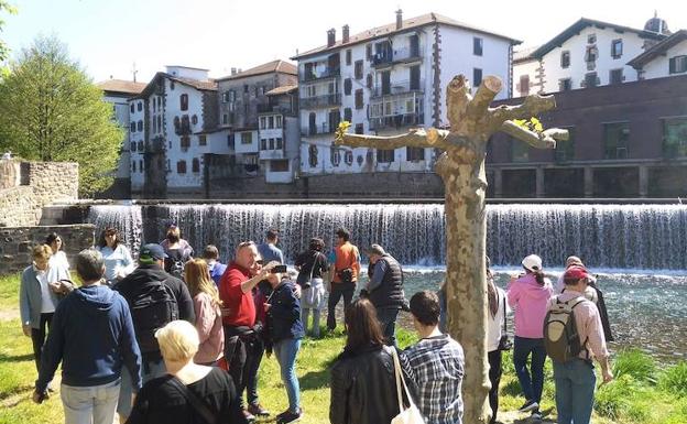 Un grupo de turistas observa el salto de agua del Baztan-Bidasoa, una de las postales clásicas de Elizondo.