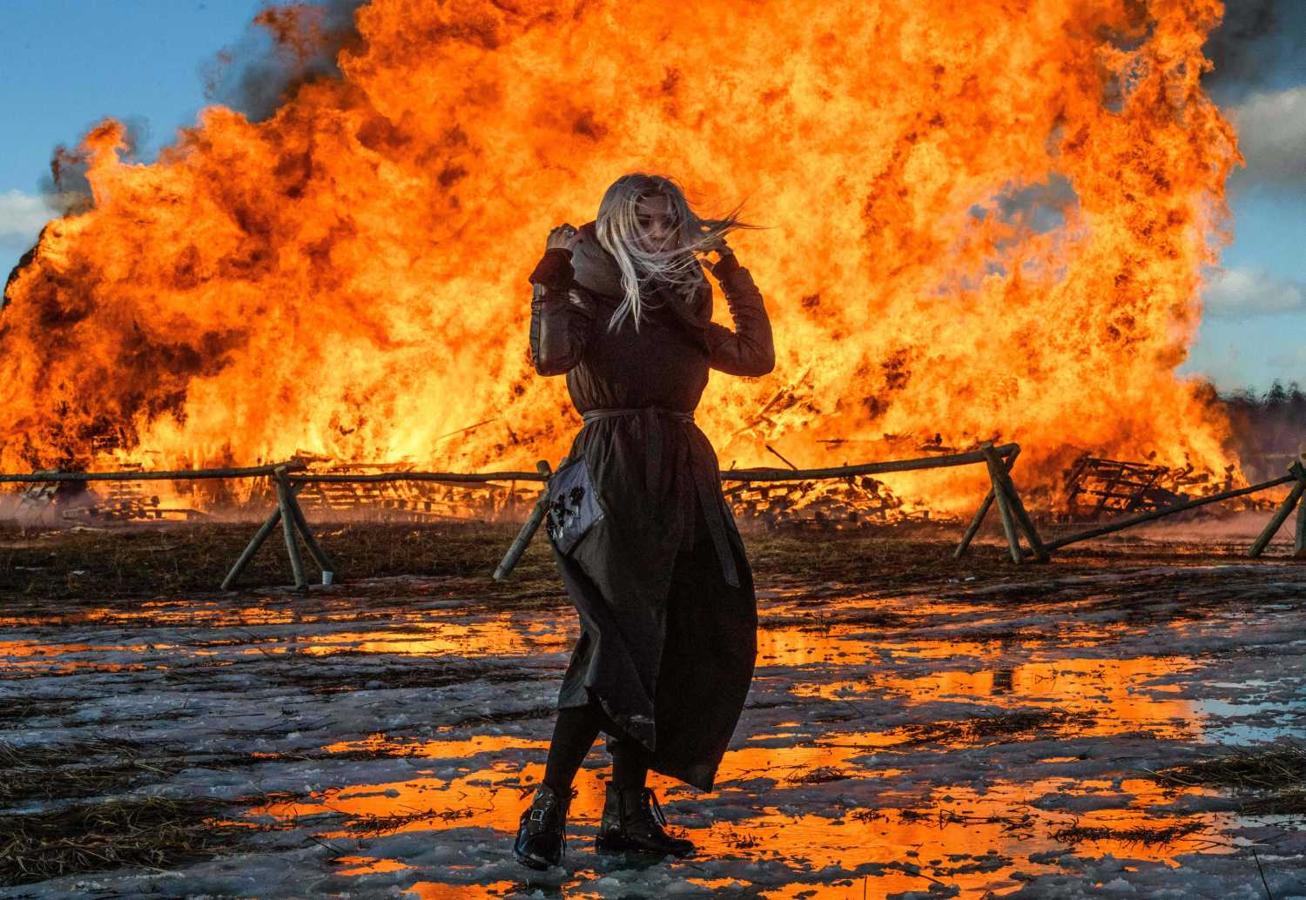 Una joven frente a una reproducción ardiendo de la Bastilla, en la celebración de la Maslenitsa, en Nikola-Lenivets, (Moscú)
