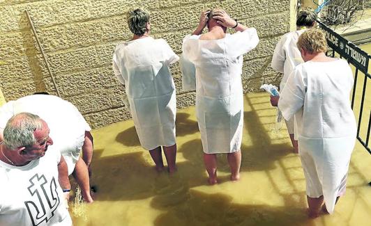 Fieles procedentes de Ucrania se bautizan por segunda vez.