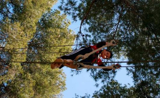 Un niño prueba su equilibrio en el parque de aventura La Gabarda.