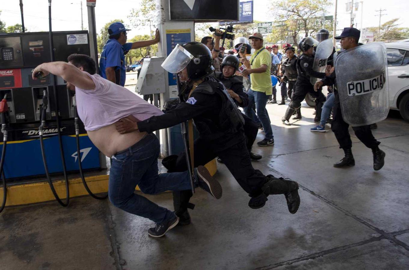 Miembros de la Policía Nacional intentan detener al reportero gráfico Luis Sequeira, de la agencia AFP, durante una manifestación contra el Gobierno de Daniel Ortega en Managua (Nicaragua). La Policía de Nicaragua replegó con violencia este sábado a un grupo de periodistas que daban cobertura a una manifestación antigubernamental, en el marco de la grave crisis sociopolítica que afecta al país. 
