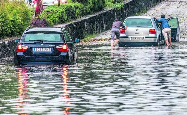 Dos vehículos atrapados en la gran balsa que se formó en el Alto de Armentia durante la tormenta del 15 de julio del año pasado, que en apenas veinte minutos anegó numerosas calles, garajes y locales de la ciudad. 