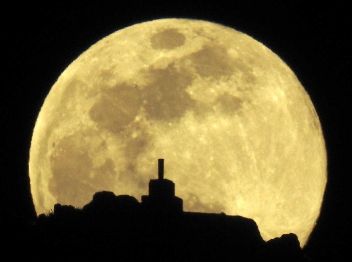 La luna llena sobre el monte Pico Sacro, a las afueras de Santiago. Se trata de la tercera superluna llena del año, y la primera que coincide con el equinoccio de primavera desde hace dos décadas