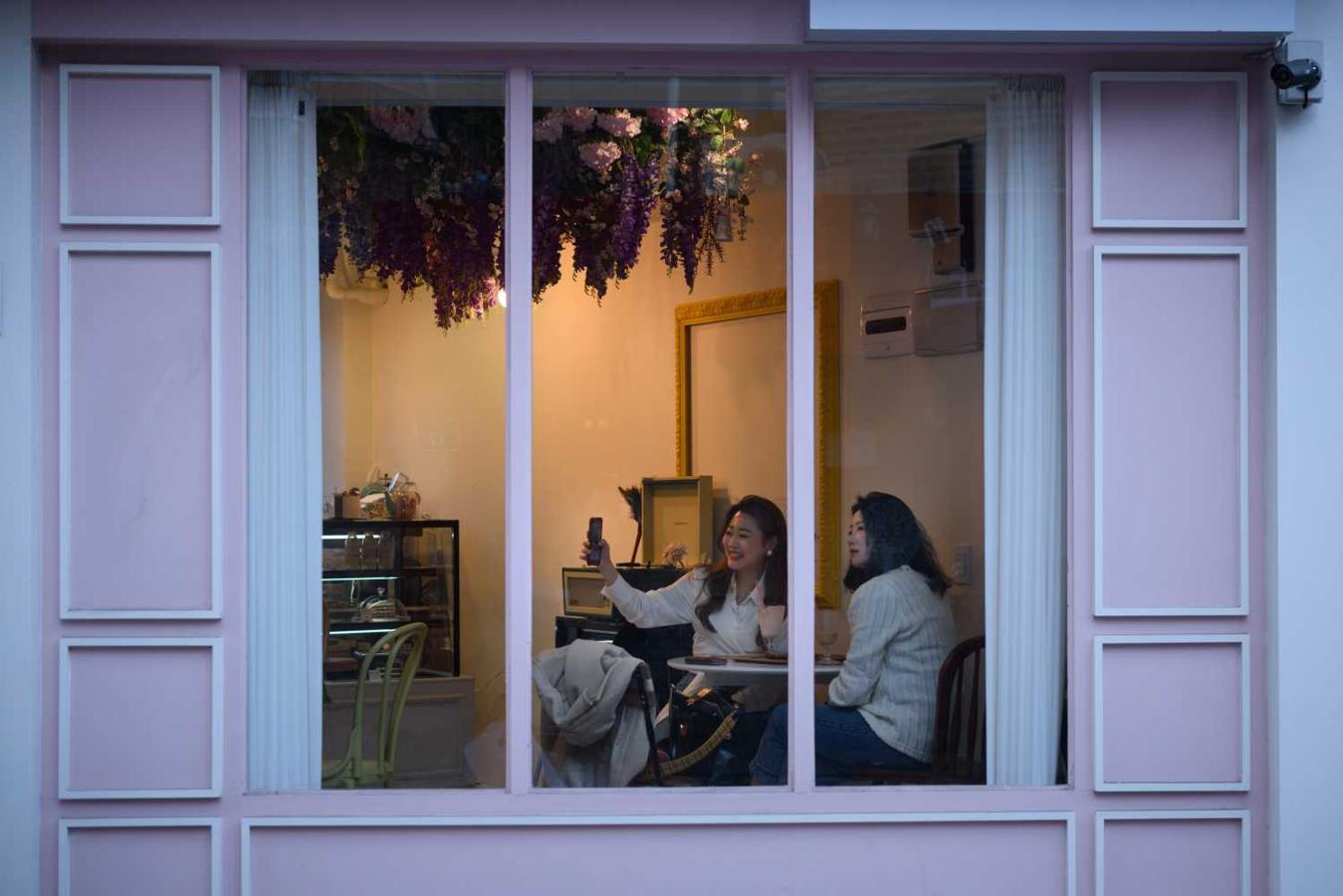 Dos mujeres sacándose un selfie en una cafetería de Seúl, Corea del Sur