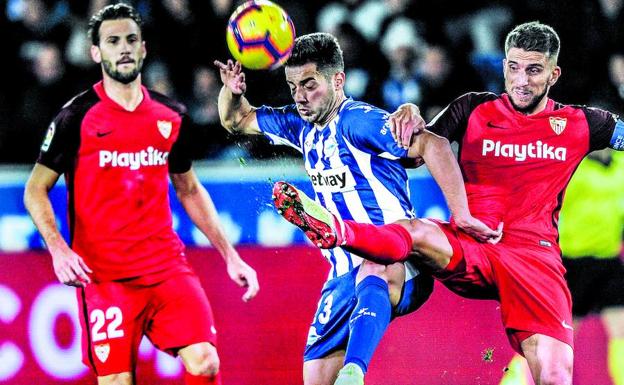 El alavesista Jony se protege ante la entrada del sevillista Carriço en el partido disputado en Mendizorroza.