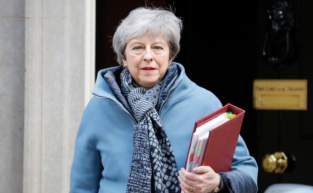 Theresa May luciendo su insepable abrigo azul, al salir este miércoles de su residencia en Downing Street.