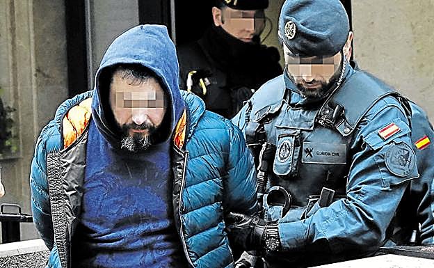 Pedro Nieva es conducido por un guardia civil tras un registro.