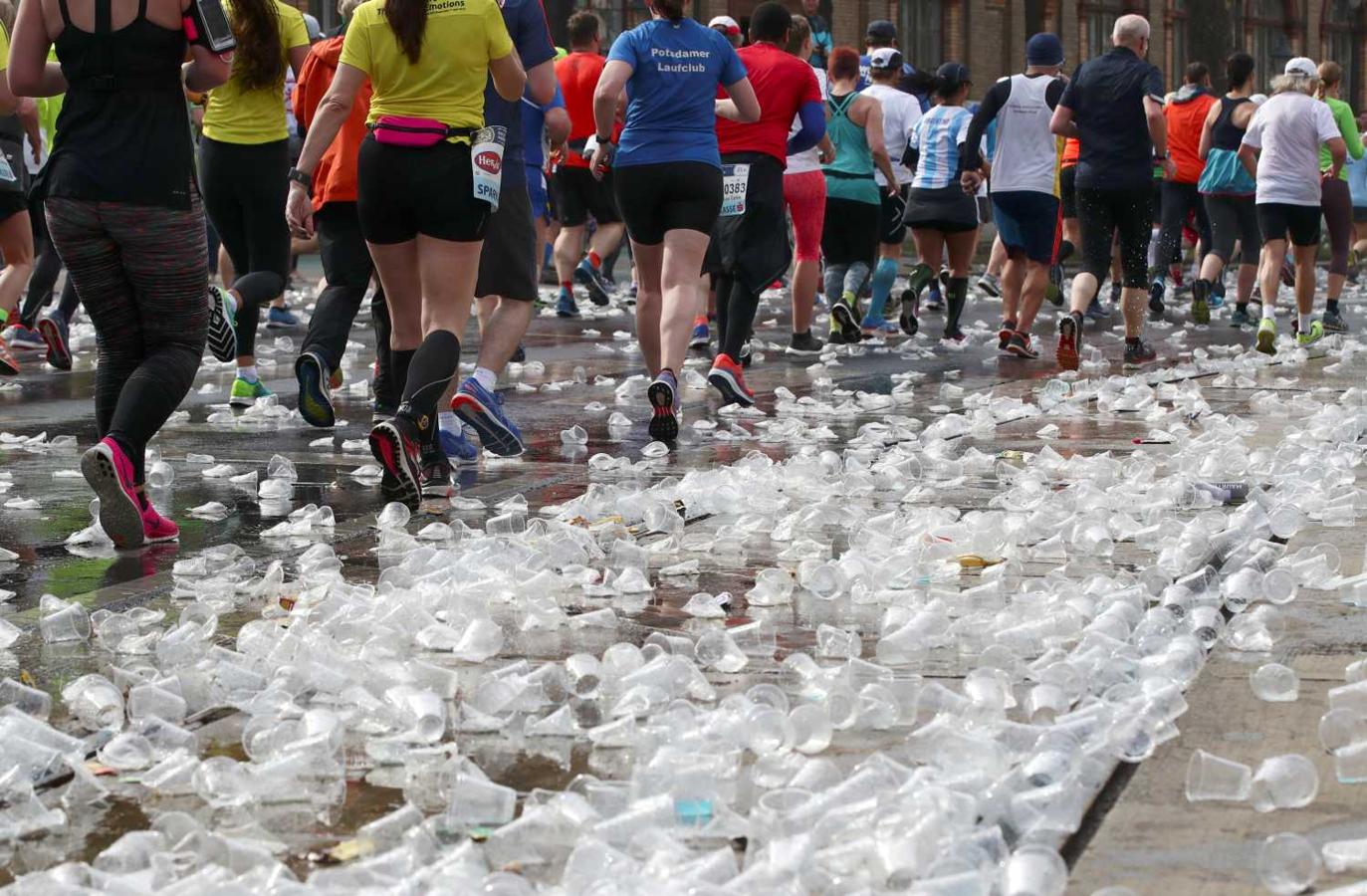 Corredores participantes del Maratón de Viena, pasan por una zona totalmente cubierta de vasos de plástico