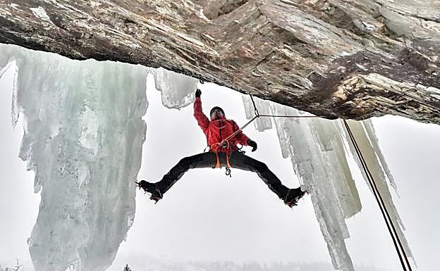 Un escalador, colgado de una cascada.