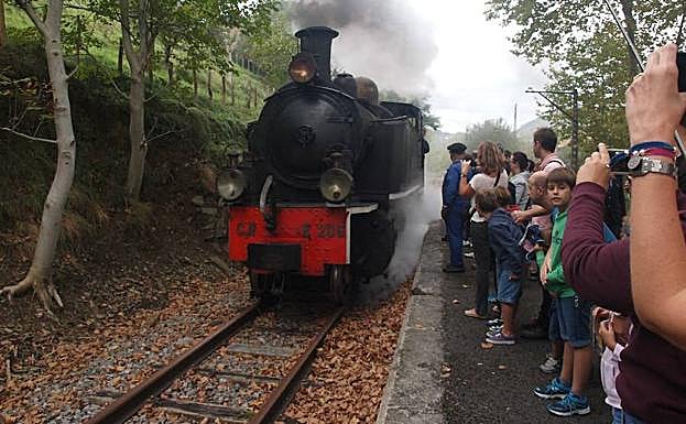 Un grupo de personas aguarda la llegada del tren de vapor. 