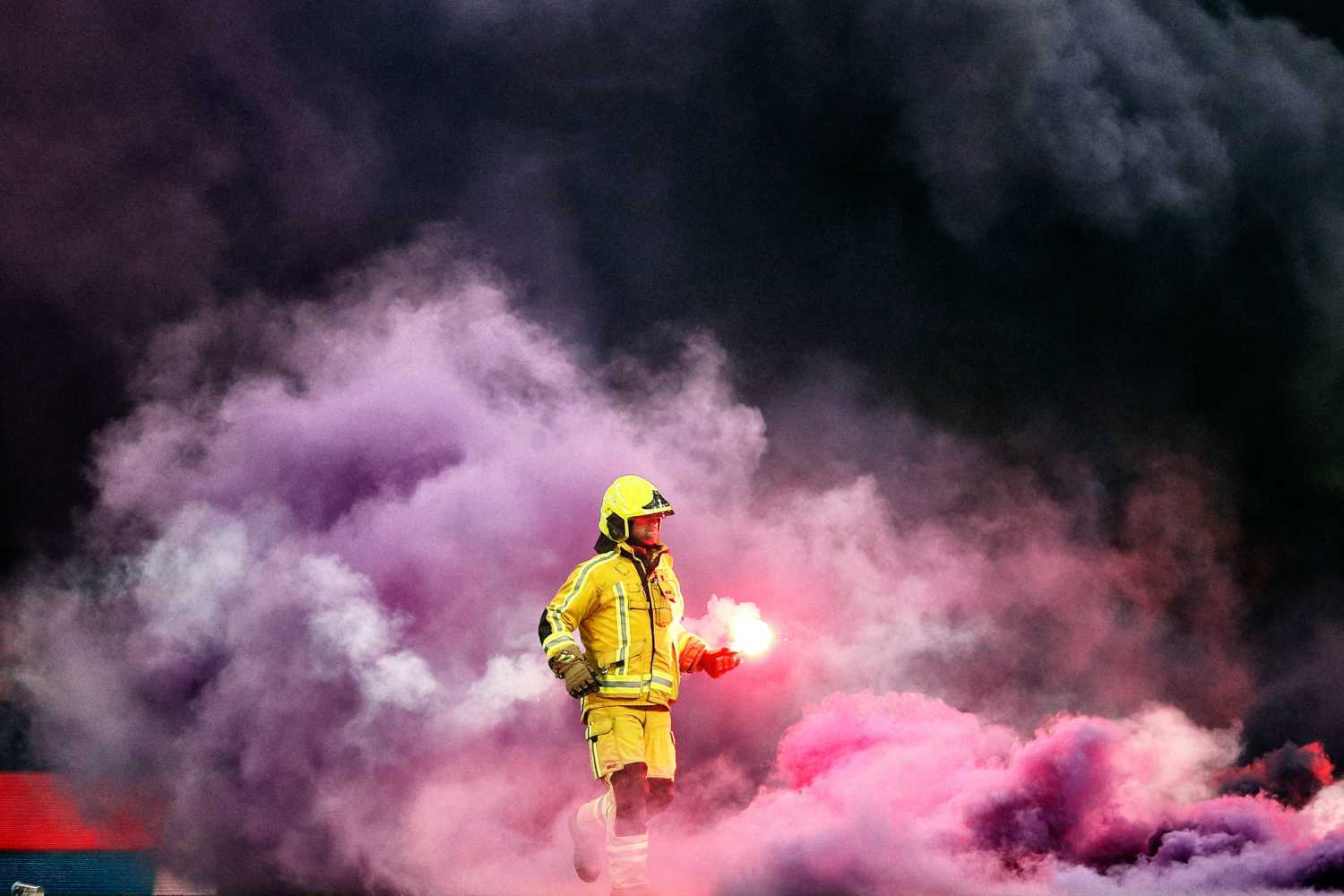 Un bombero sofoca una llamarada en el estadio de Liege, donde juegan los equipos Standard de Liege y RSC Anderlecht 