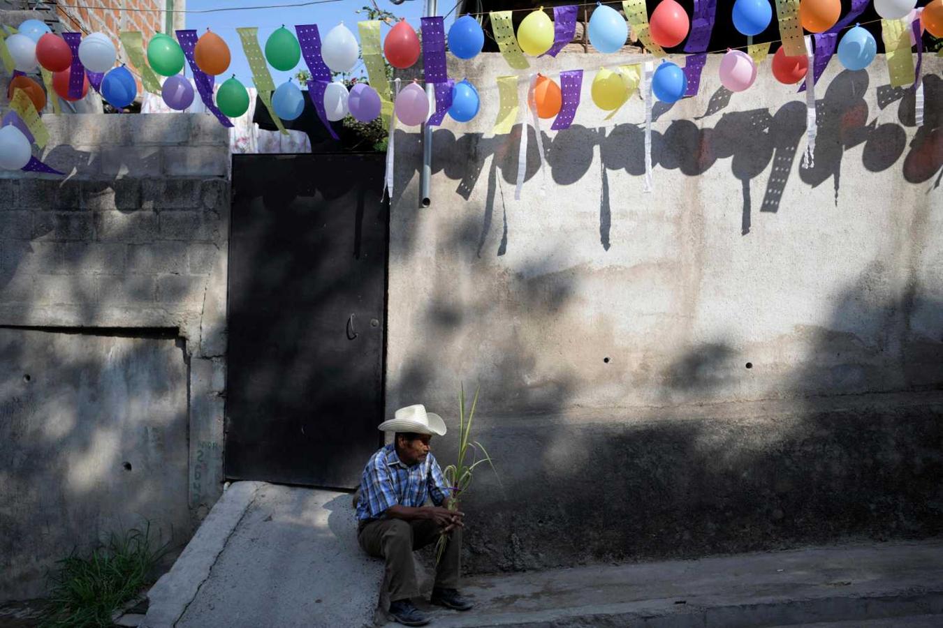Un hombre espera la tradicional procesión del Domingo de Ramos en Panchimalco, en El Salvador