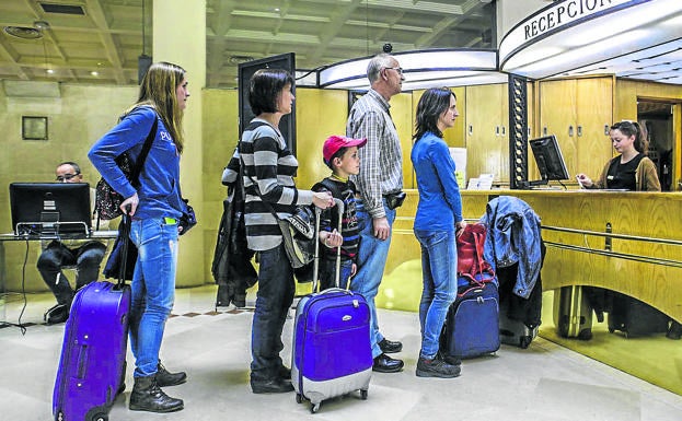 Visitantes hacen cola para registrarse en uno de los hoteles de la capital alavesa. 