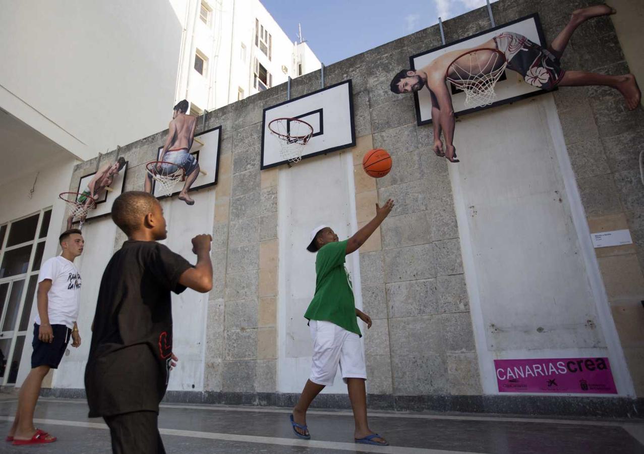 Jóvenes juegan en la instalación "Basket People", de los artistas españoles Martín y Sicilia, parte del proyecto Detrás del Muro, en La Habana (Cuba). "Detrás del muro", la muestra estrella de la XIII Bienal de La Habana (12 de abril al 11 de mayo), transforma durante un mes el emblemático Malecón e invita a los visitantes al diálogo y la interacción con el arte. 