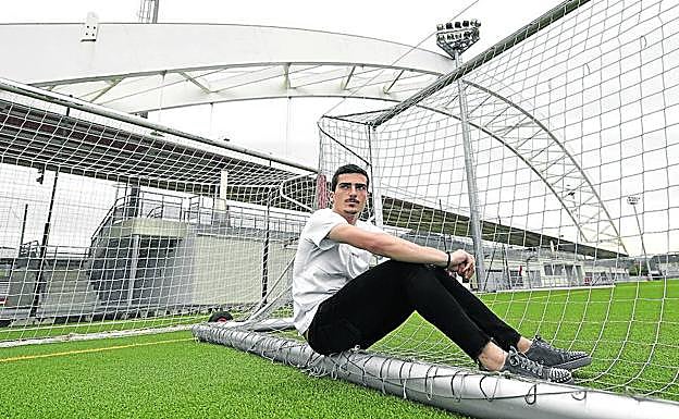 Iñigo Córdoba posa en uno de los campos en entrenamiento de Lezama, con el antiguo arco de San Mamés al fondo.