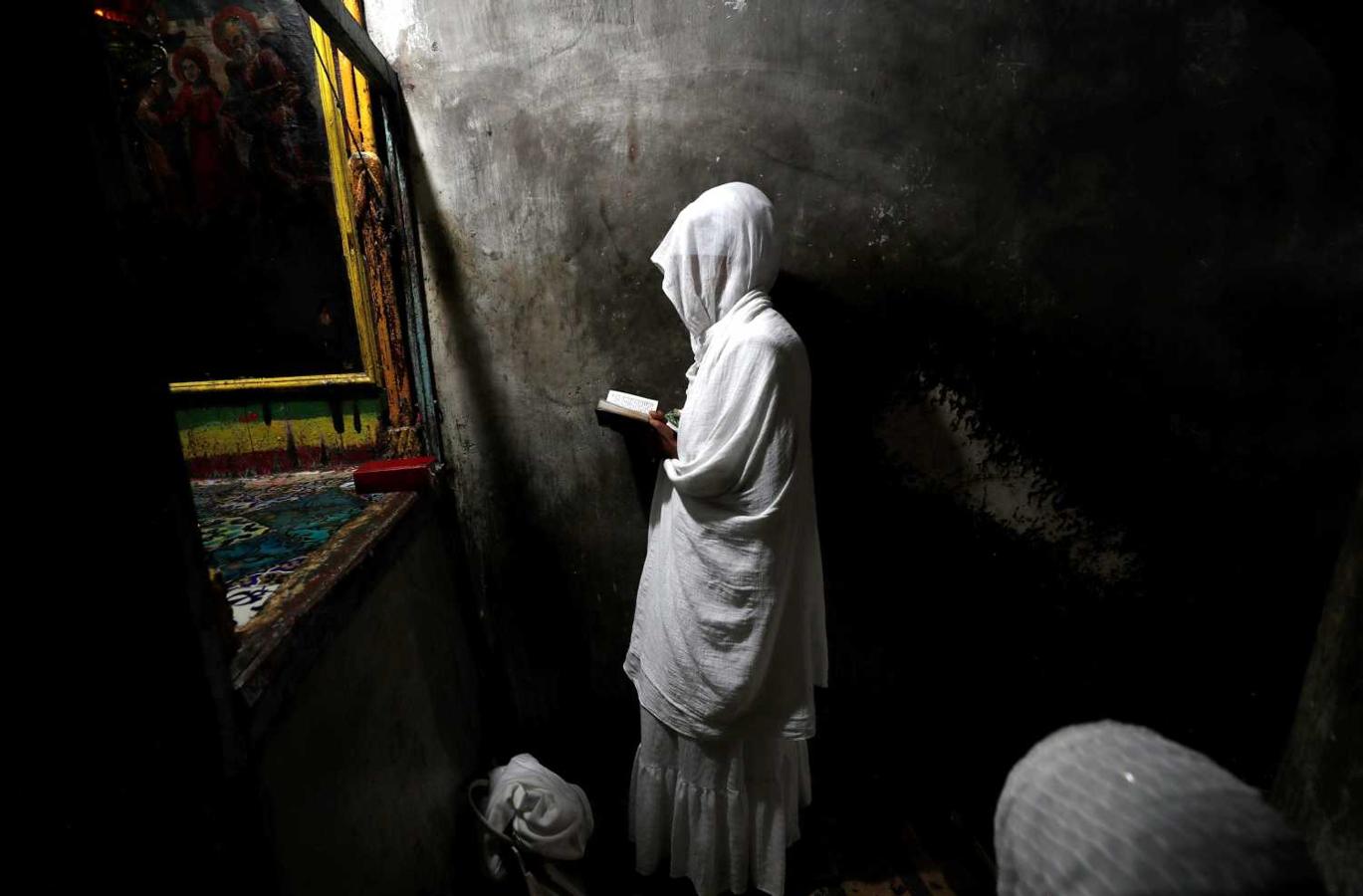 Una peregrina ortodoxa etíope reza en la iglesia etíope de Deir Al Sultan, en el exterior de la Iglesia del Santo Sepulcro, durante la tradicional ceremonia de lavado de pies, en el casco viejo de Jerusalén