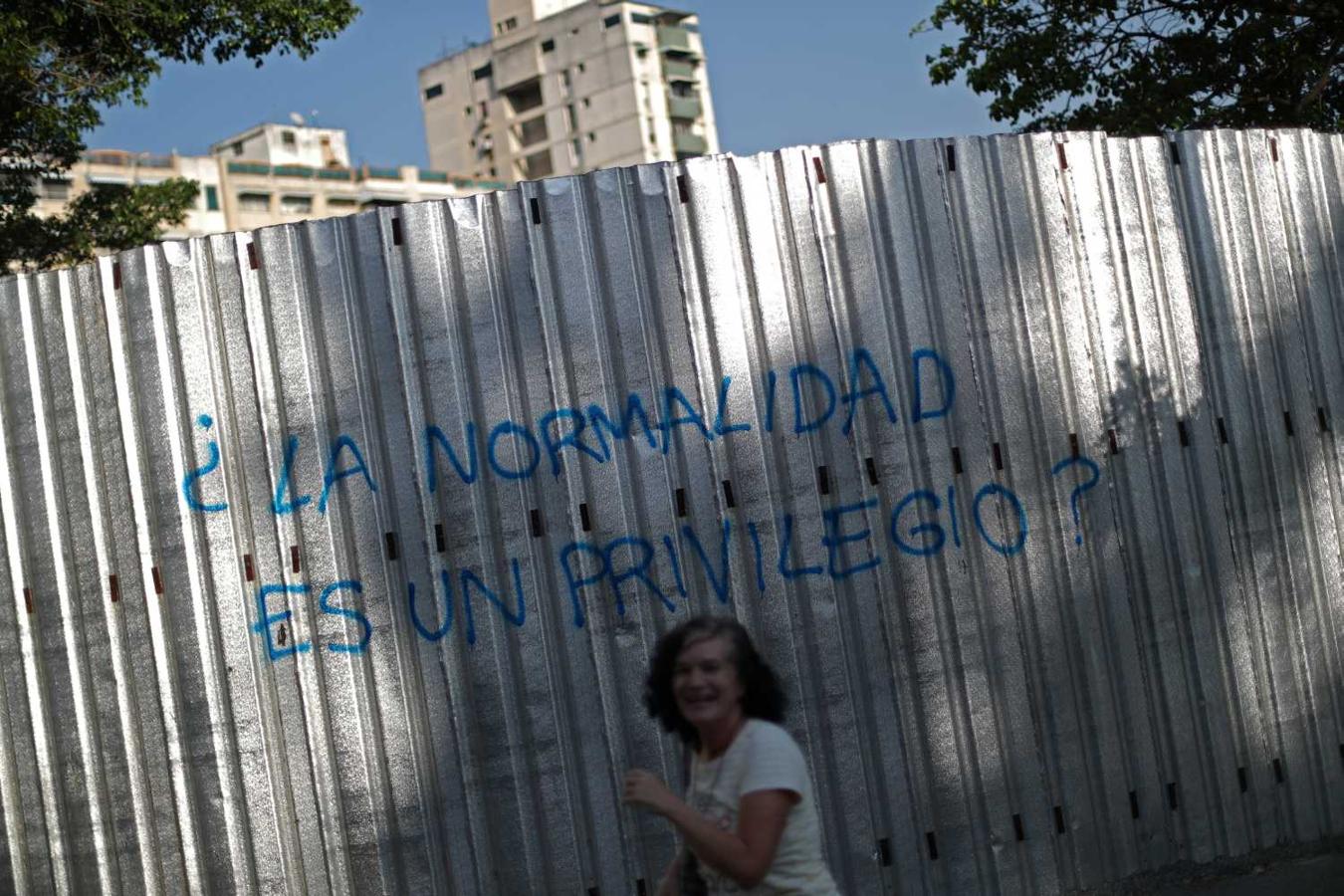 Belinda, ex maestra, se ríe después de tomar una fotografía de un graffiti que dice "¿La normalidad es un privilegio?" en Caracas. "Nosotros, el pueblo venezolano, hacemos una broma de todo", dijo Belinda.