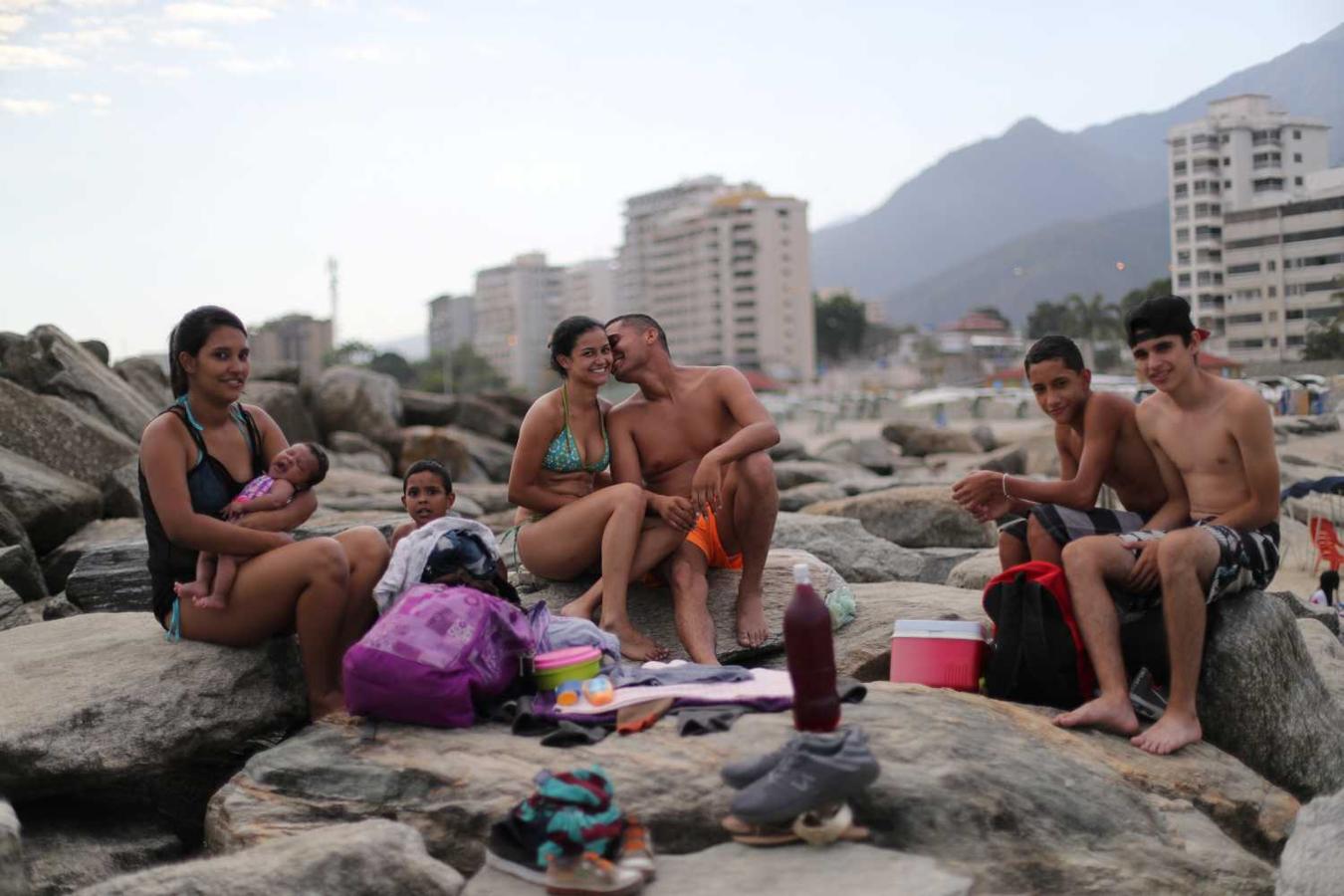 Leonel Martínez, que trabaja como soldado, besa a su novia mientras pasan un día en la playa de Coral en La Guaira, cerca de Caracas, Venezuela. "Es una forma de pensar en algo más que lo que está sucediendo en el país", dijo. Martínez. "No es algo que se pueda hacer todos los días, debido a la situación en el país".