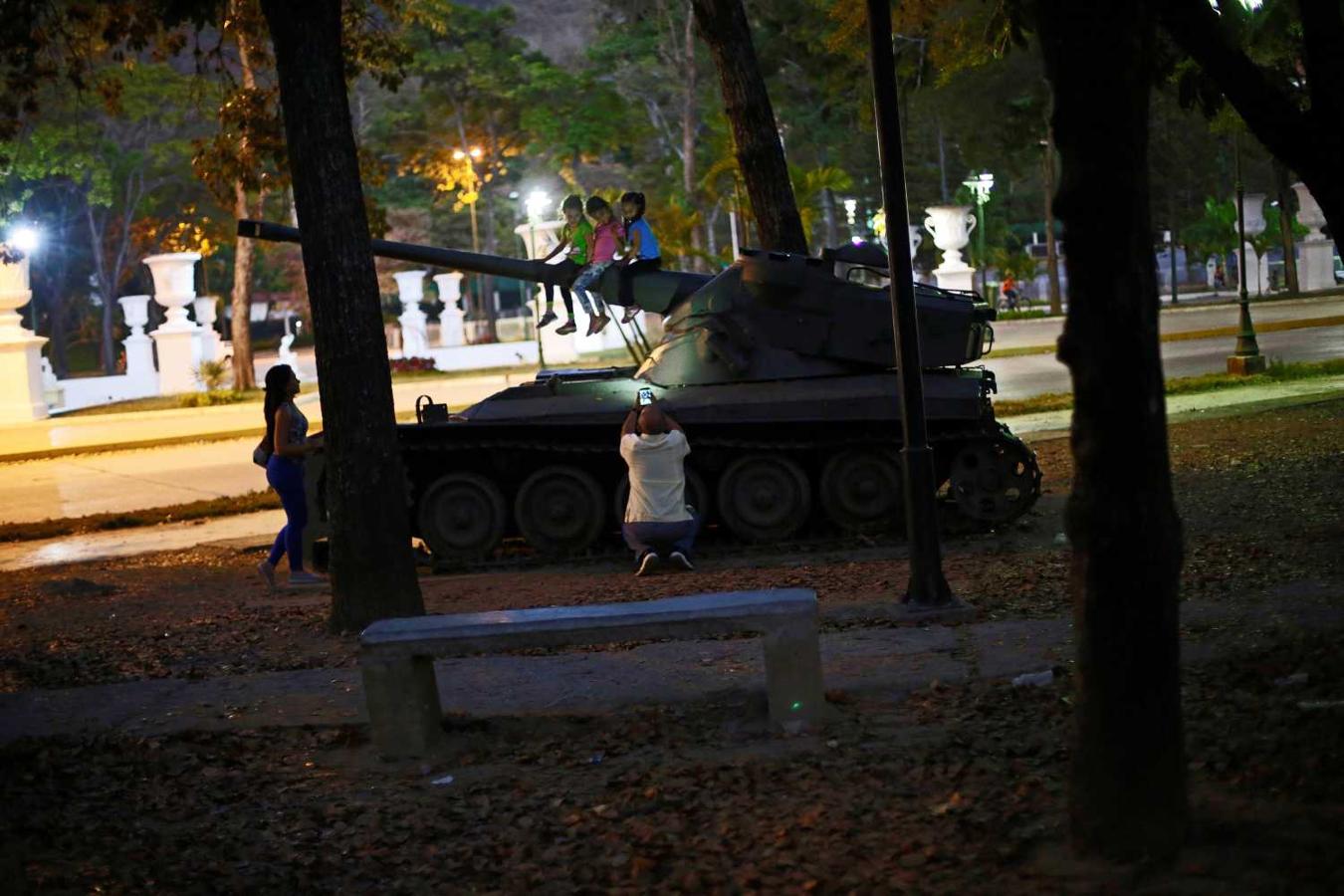 Niños posan para una fotografía en un tanque en desuso exhibido en el bulevar Los Proceres en Caracas, Venezuela