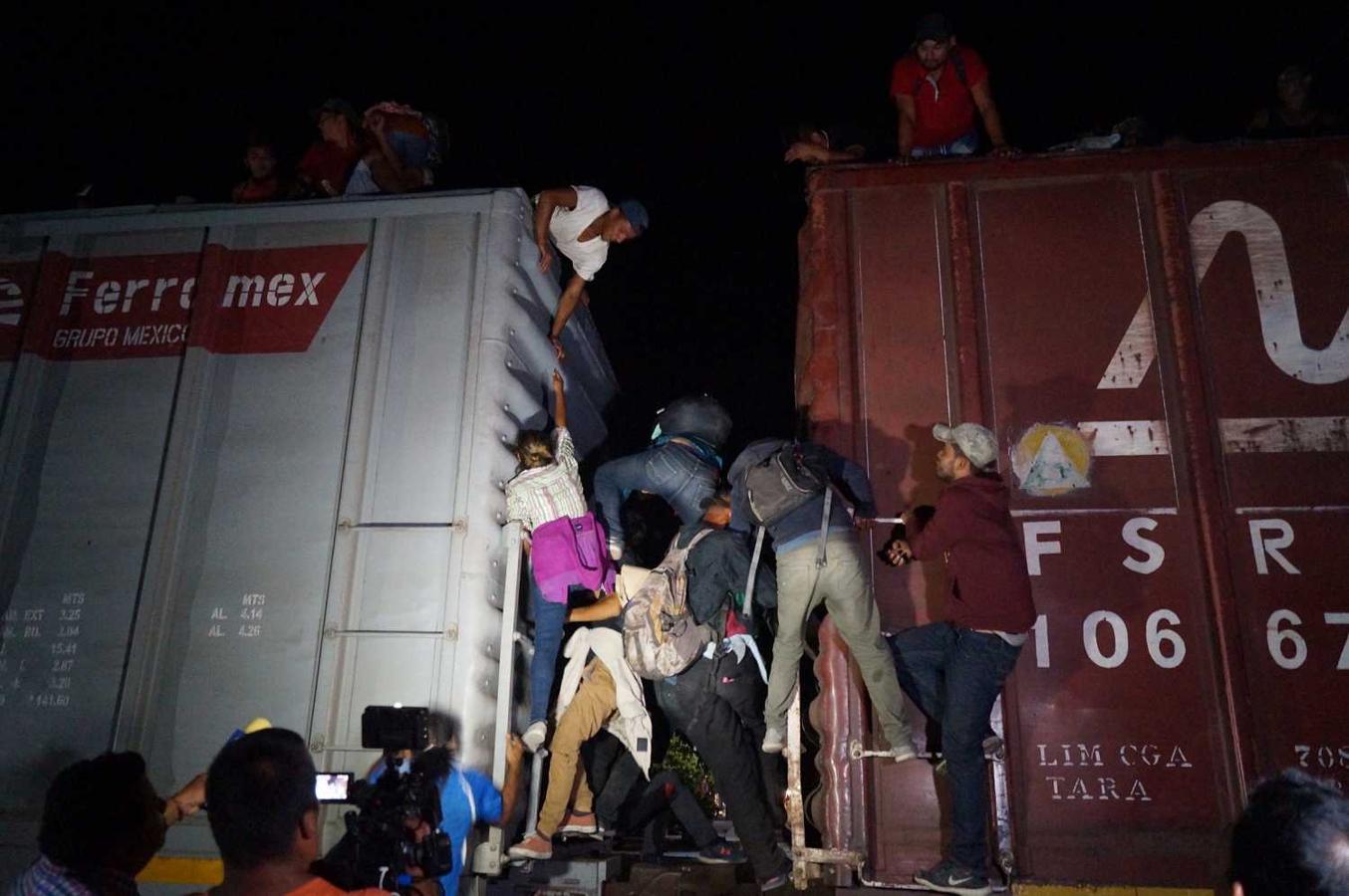 Migrantes centroamericanos suben en la madrugada a las góndolas del tren llamado "La Bestia", en el municipio de Arriaga, estado de Chiapas (México). Cientos de migrantes han conseguido subir al tren "La Bestia" en una zona controlada por decenas de puntos de revisión que las autoridades mexicanas han impuesto. 